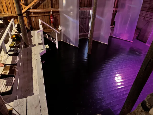 Katsomo ja violetissa valossa hohtava näyttämö